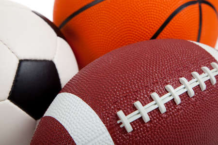 Assorted sports equipment on white including a basketball, a soccer ball, and an American Footballの写真素材