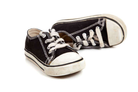 A young childs tennis shoes on a white background with copy spaceの写真素材