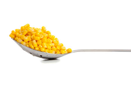 A kitchen spoon with a heaping serving of fresh yellow cut cornの写真素材