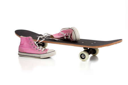 A skate board and pink sneakers on a white background with copy spaceの写真素材