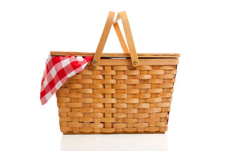 A brown wicker picnic basket on a white background with gingham clothの写真素材