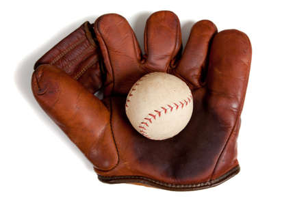 A vintage, antique leather baseball glove with a baseball on a white backgroundの写真素材