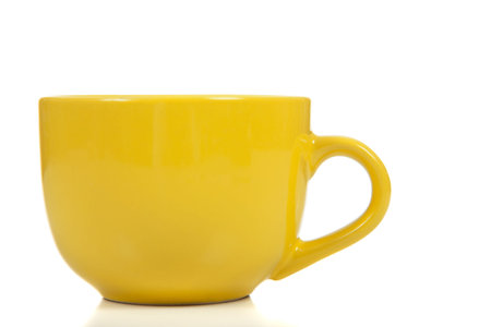 A yellow coffee cup on a white background with copy space