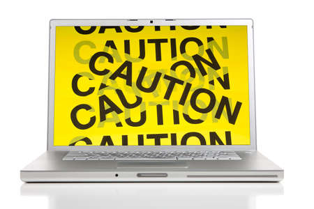 A silver computer with caution barrier tape on the screen.  Computer security conceptの写真素材