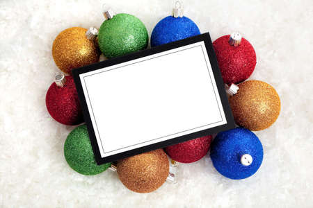 A Christmas themed notecard or message surrounded by baubles and ribbon.  Use as invitation or announcement, with copy spaceの写真素材
