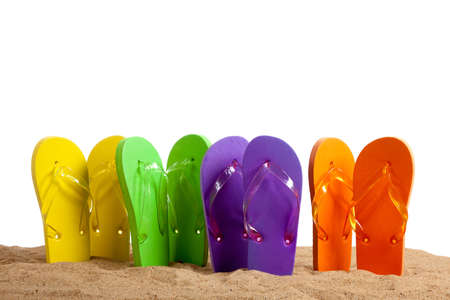 Four pairs of colorful flip-flop sandles on a beach background, studio shotの写真素材