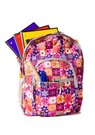 Colorful school back pack overflowing with school supplies including pens, pencils. tablets,...