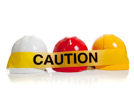 various colored hard hats with caution tapeの写真素材