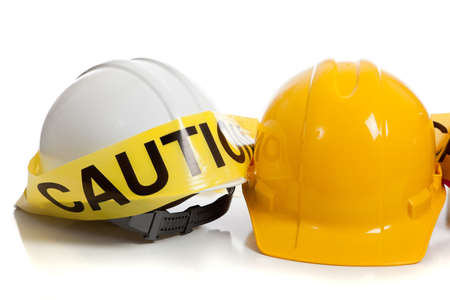 various colored hard hats with caution tapeの写真素材