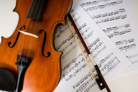A violin and bow laing on sheet musicの写真素材