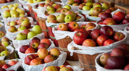 Several baskets of red and green apples at a fruit stantの写真素材