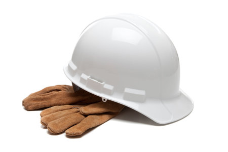 A white hard hat and leather work gloves on a white backgroundの写真素材