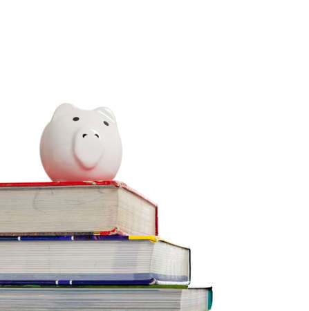A stack of textbooks with a white piggy bank on a white backgroundの写真素材