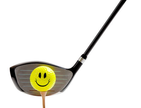 A yellow, smiley face golf ball on a ree with a driver on a white backgroundの写真素材