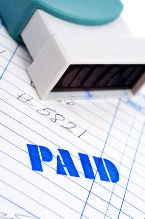 Blue paid stamped on an invoice on a white backgroundの写真素材