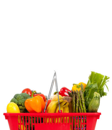 Red shopping basket with vegetables including peppers, asparagus, celery, tomatoes, squash and broccoli on a white background with copy spaceの写真素材