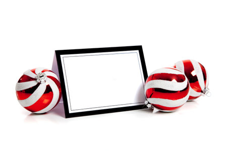 Red and white striped Christmas balls/baubles on a white background with a blank notecard