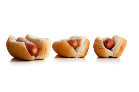 A row of hot dogs and buns on a white backgroundの写真素材