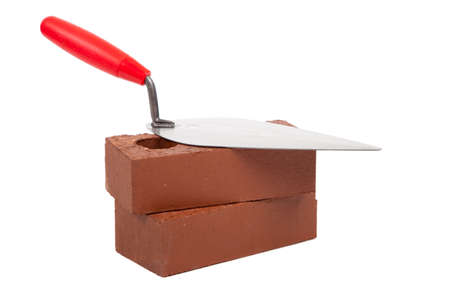 A stack of bricks with a mortar trowel on a white backgroundの写真素材