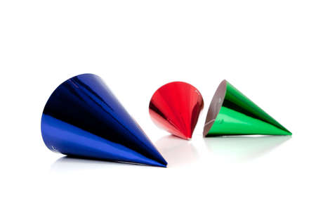 Assorted party hats including red, green, and blue on a white background with copy spaceの写真素材