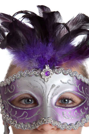 A girl in a purple madi gras mask on a white backgroundの写真素材