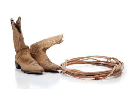 Cowboy boots and lariat rope on white with copy spaceの写真素材