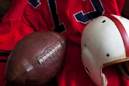 A group of vintage, antique American football equipment including a jersey, football and a helmetの写真素材