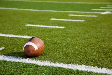 A American football on a green football fieldの写真素材