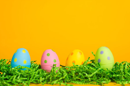 4 assorted colored Easter eggs on a yellow background
