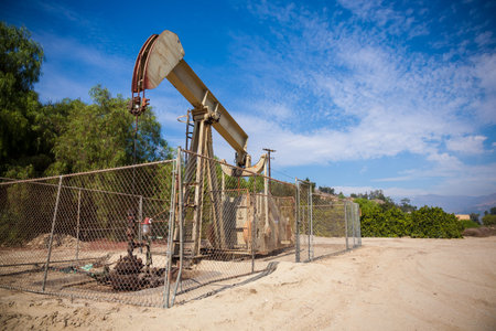 A horsehead pumpjack with a blue sky background with clouds