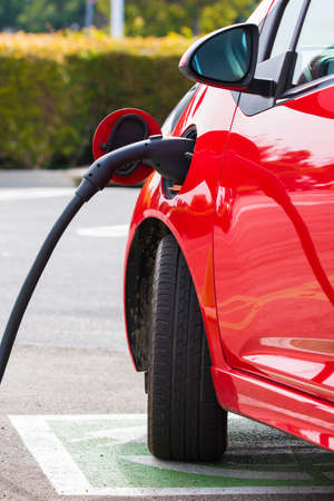 An electric vehichle, car charging at a public stationの写真素材