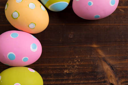 A group of colorful easter eggs ona a wooden plank backgroundの写真素材