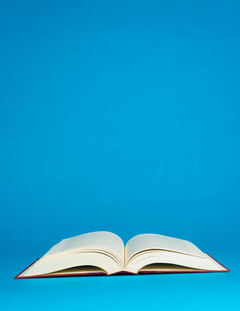 Open book on a blue background with copy spaceの写真素材