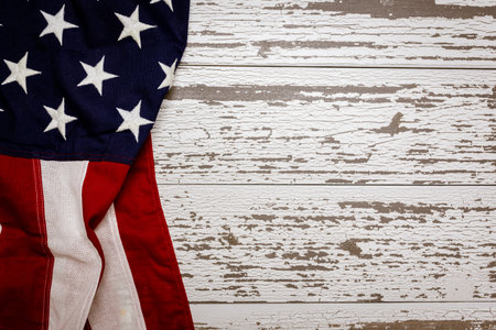 A crumpled American flag on a white plank background with copy space for holidays etc.