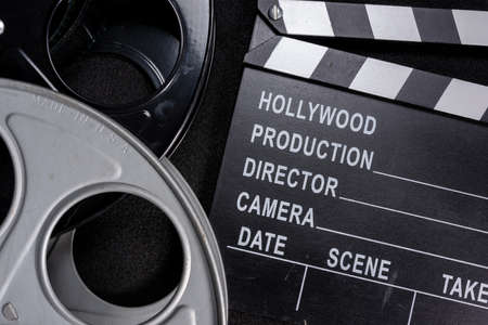 Movie clapper and film reel on a wooden backgroundの写真素材