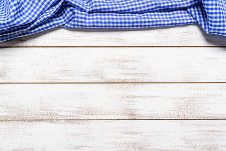 a checked gingham picnic tablecloth on old wooden table top viewの写真素材
