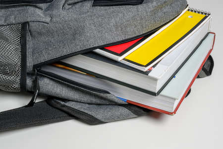 School backpack on a white background with books and spiral notebooksの写真素材