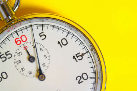 A classic 60 second stopwatch on a yellow backgroundの写真素材