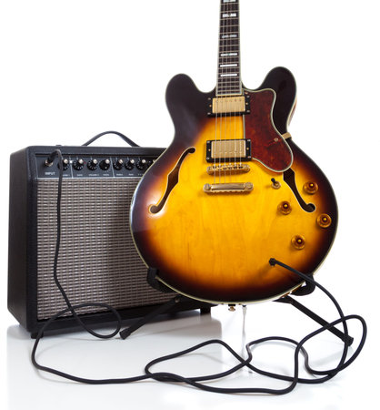 Vintage semi solid electric guitar and amplifier on white