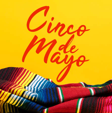 Mexican Serape blanket on yellow background with Cinco de Mayo.の写真素材