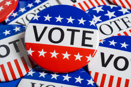 A group of red, white and blue VOTE button on a blue backgroundの写真素材