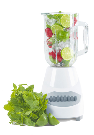 Fresh lime and strawberry with ice inside blender on a white backgroundの写真素材