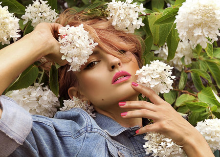 beautiful yuong woman  pose in flowers in summer day