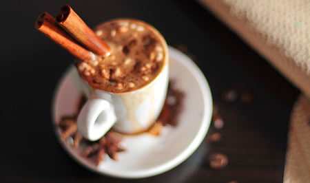 Cup of coffee and cinnamon on wood tableの写真素材