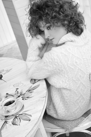 Happy woman in warm sweater with curly hair, smilingの写真素材