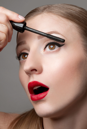 Close up of woman face with mascara brush. Eyes Make up with Perfect Skinの写真素材