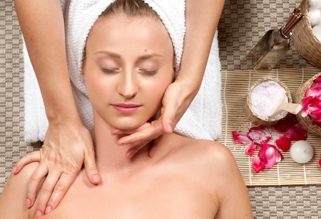 portrait of young beautiful woman in spa environment lying with closed eyes, Masseur doing massage the head of woman in the spa salonの写真素材