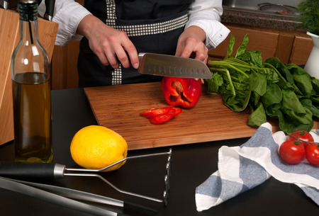 Woman cooking in kitchen making healthy food. Cook cutting vegetablesの写真素材