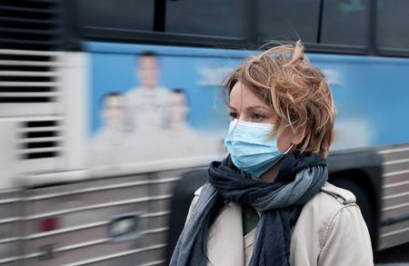 Portrait of woman walking on the street wearing protective mask as protection against infectious diseases. 
の写真素材