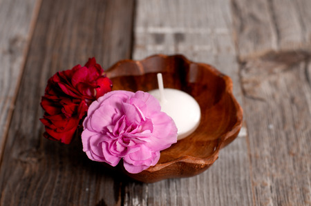 Spa, wellness or body care concept. Flowers in wooden bowl on tableの写真素材